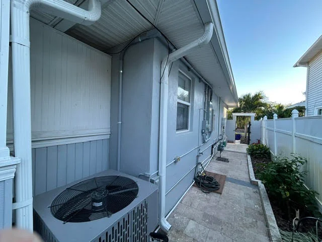Heat pump unit with electrical conduit and disconnect switch on exterior wall