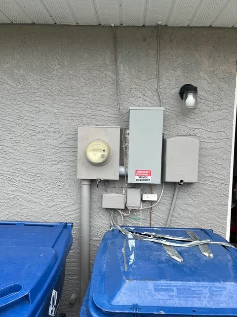 Electrical meter, disconnect switch, and breaker panel mounted on concrete wall with conduit