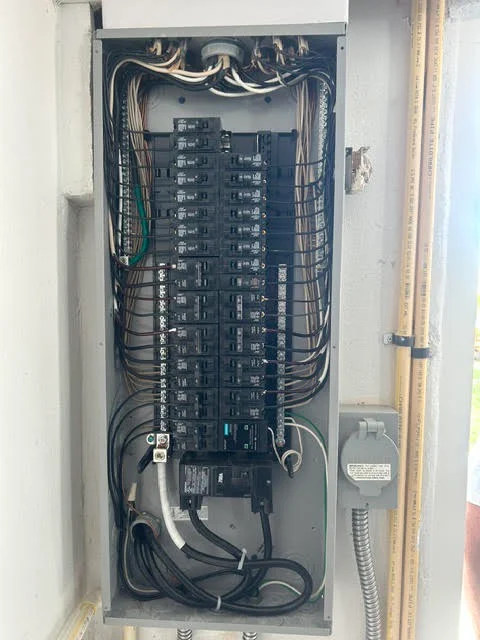 Electrical panel upgrade with organized breakers, new wiring, and conduit installation