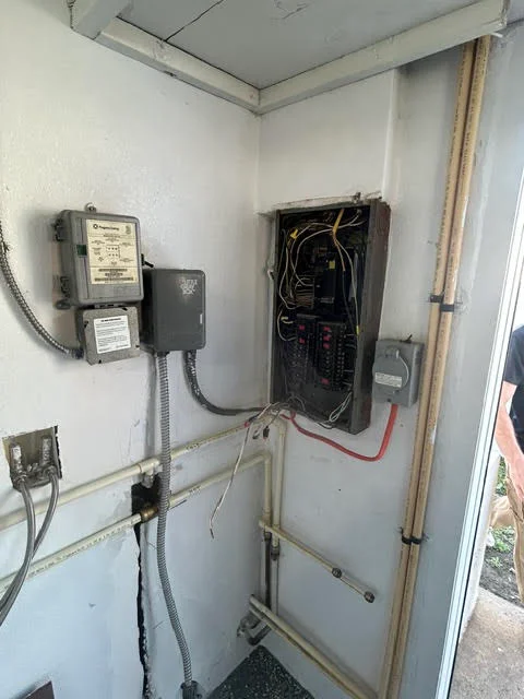 Electrical panel with breaker box, meter, and organized conduit wiring installation