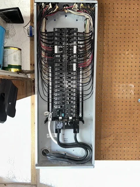 Open electrical panel with organized breaker circuits and color-coded wiring connections