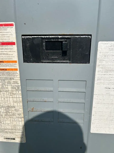 Recessed black electrical panel with circuit breakers installed in drywall wall
