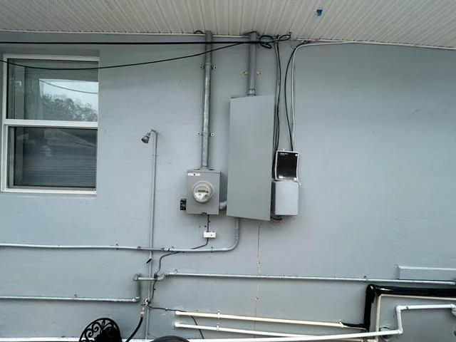 RV exterior electrical installation with tankless heater, meter, and conduit wiring